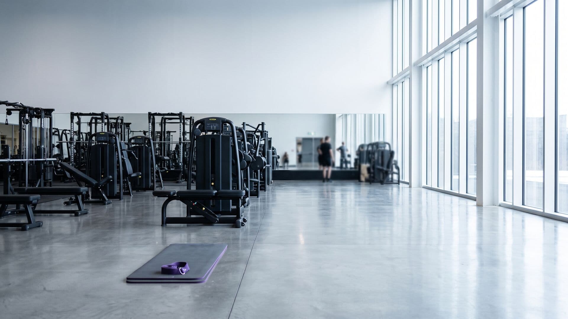 Sala de musculación de un centro deportivo a primera hora, con las máquinas alineadas y la luz entrando por el ventanal